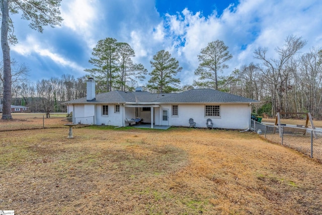 rear view of property featuring a lawn and a patio