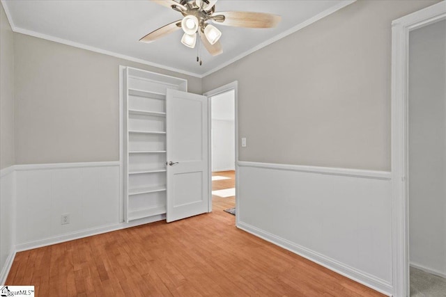 unfurnished bedroom featuring ceiling fan, light wood-type flooring, and ornamental molding