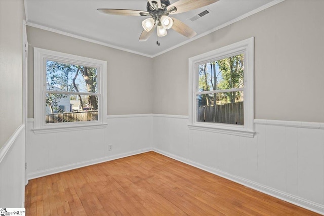 empty room featuring ceiling fan, light hardwood / wood-style floors, and ornamental molding