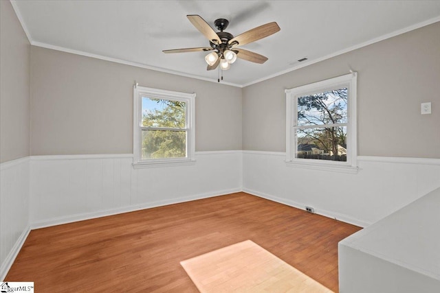 empty room featuring hardwood / wood-style floors, ceiling fan, and crown molding