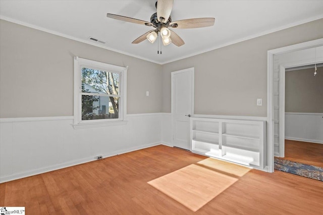 empty room featuring hardwood / wood-style floors, ceiling fan, and ornamental molding