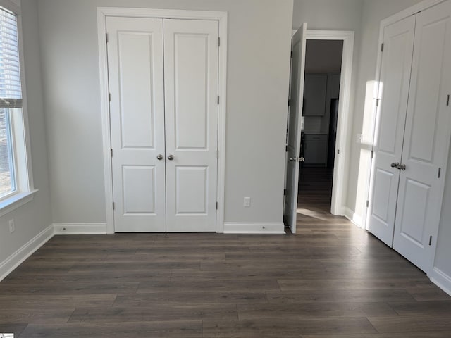 unfurnished bedroom with dark wood-type flooring