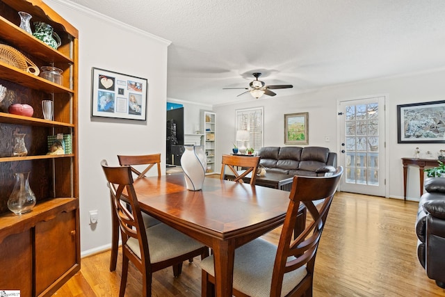 dining room featuring ceiling fan, light hardwood / wood-style floors, a textured ceiling, and ornamental molding