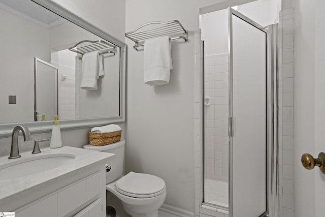 bathroom featuring ornamental molding, vanity, toilet, and a shower with shower door