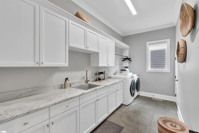 clothes washing area with cabinets, separate washer and dryer, crown molding, and sink