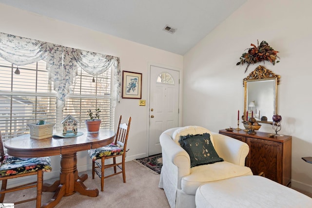 carpeted dining room featuring lofted ceiling