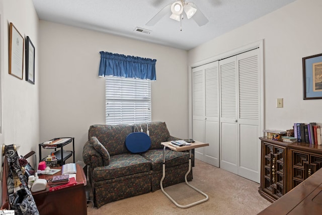 office featuring ceiling fan, light colored carpet, and a textured ceiling