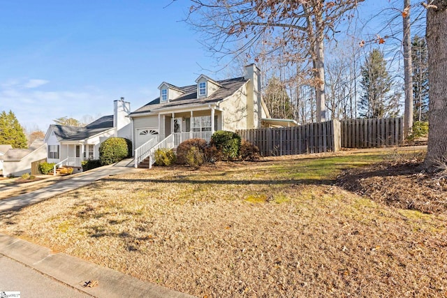 cape cod house featuring a garage, covered porch, and a front lawn