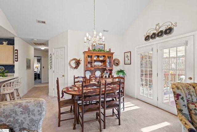 dining space featuring a notable chandelier, light colored carpet, and lofted ceiling