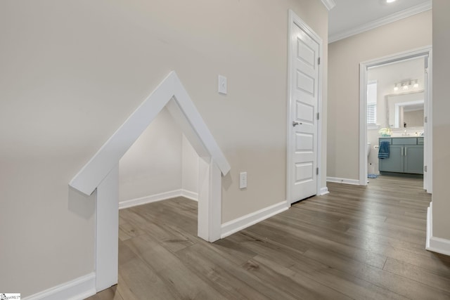 hall with light wood-type flooring and ornamental molding