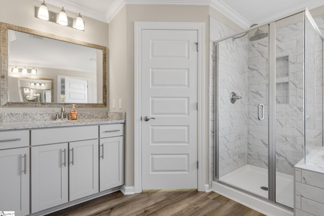 bathroom featuring vanity, hardwood / wood-style flooring, walk in shower, and crown molding