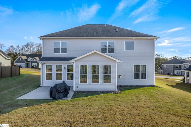 rear view of property featuring a lawn and a patio