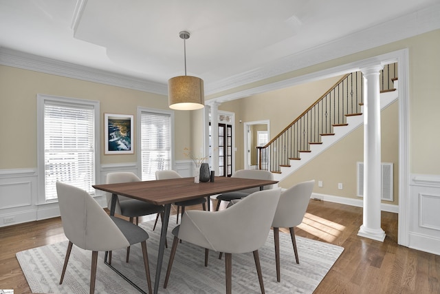 dining area featuring dark hardwood / wood-style flooring, decorative columns, crown molding, and french doors