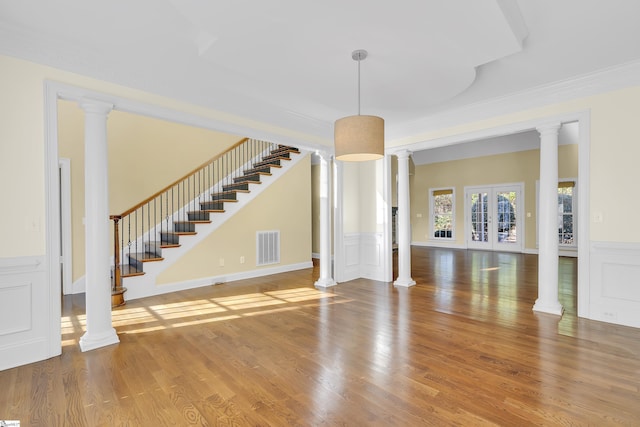 unfurnished living room featuring french doors, wood-type flooring, and ornamental molding