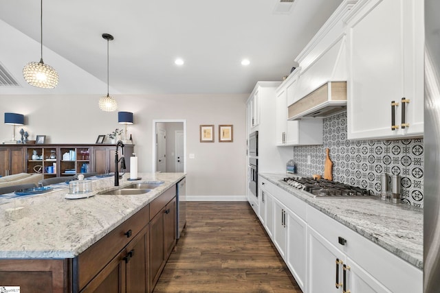 kitchen with sink, dark hardwood / wood-style flooring, decorative light fixtures, white cabinets, and appliances with stainless steel finishes