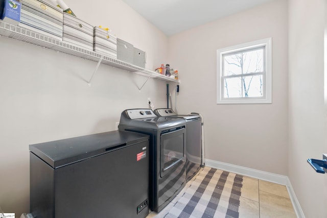 laundry room featuring washer and dryer and light tile patterned flooring