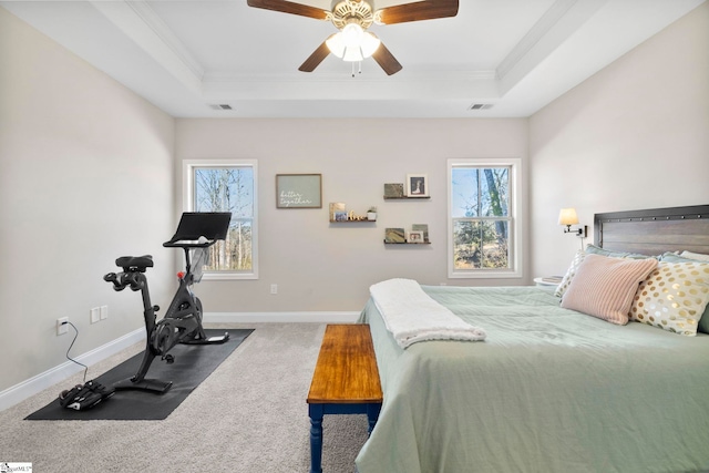 bedroom with dark colored carpet, ceiling fan, multiple windows, and a tray ceiling