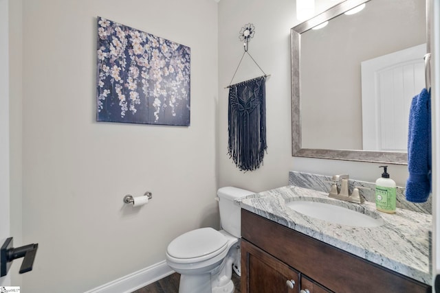 bathroom with hardwood / wood-style floors, vanity, and toilet