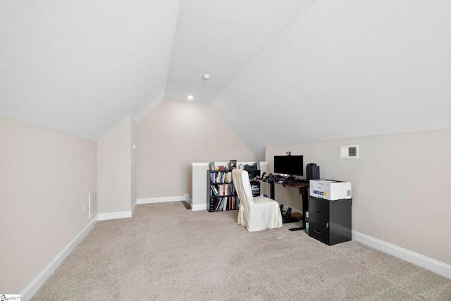 office space with light carpet and vaulted ceiling