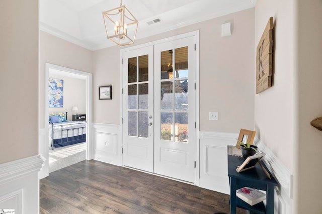 doorway to outside featuring a chandelier, ornamental molding, dark wood-type flooring, and french doors