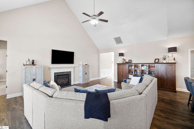 living room with dark hardwood / wood-style floors, ceiling fan, and high vaulted ceiling