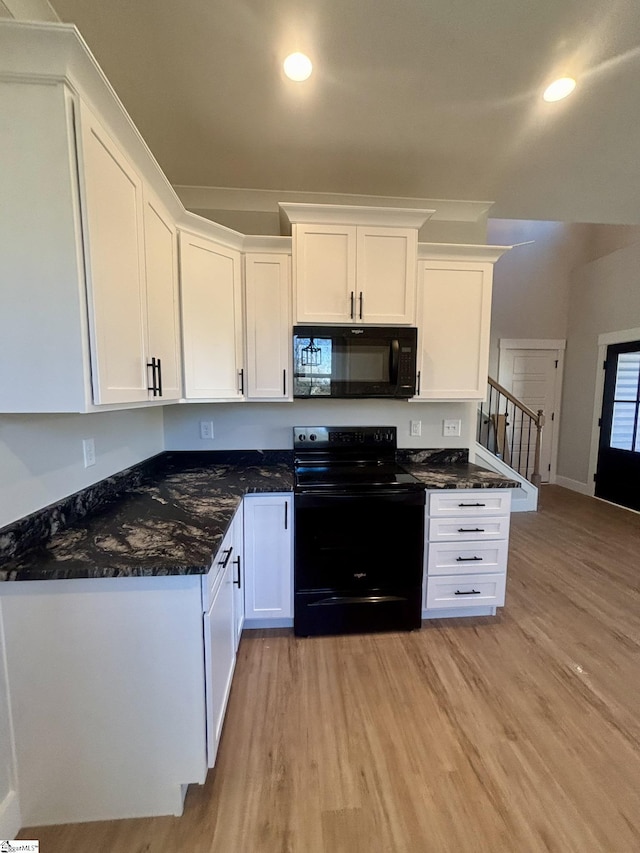 kitchen with black appliances, light hardwood / wood-style floors, white cabinetry, and dark stone counters