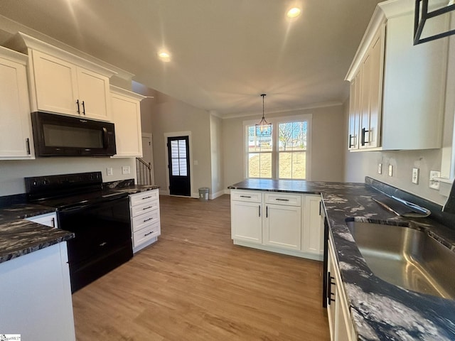 kitchen with pendant lighting, black appliances, white cabinets, sink, and light hardwood / wood-style flooring