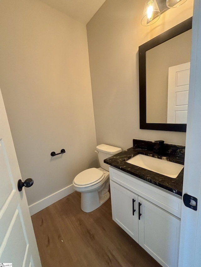 bathroom featuring vanity, hardwood / wood-style flooring, and toilet