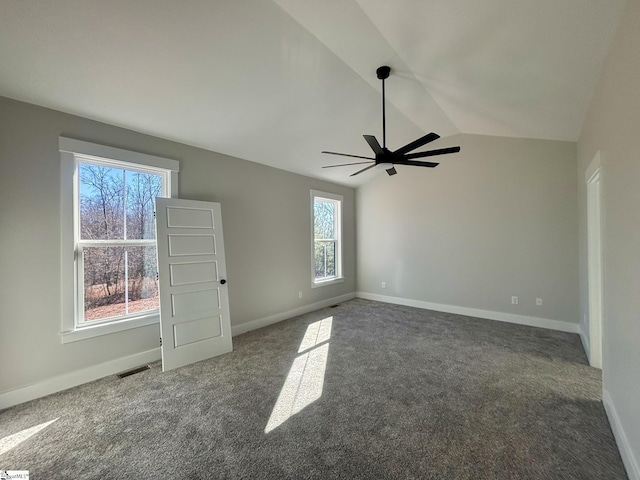 empty room with dark colored carpet, ceiling fan, and lofted ceiling