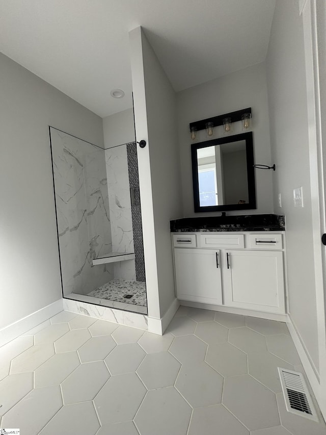 bathroom featuring tile patterned floors, vanity, and tiled shower