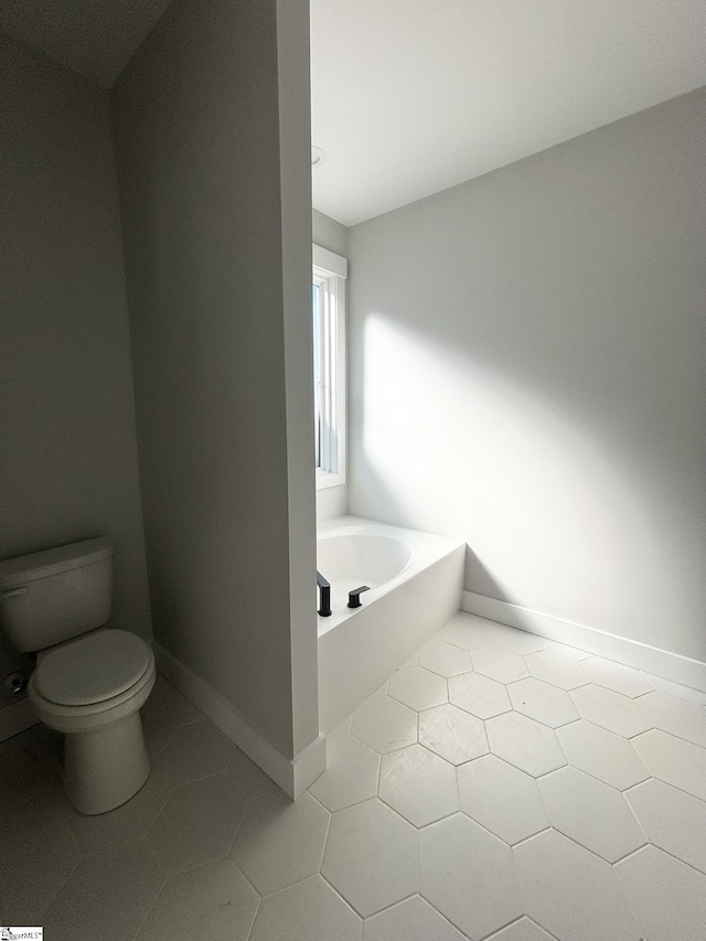 bathroom with tile patterned flooring, a bath, and toilet