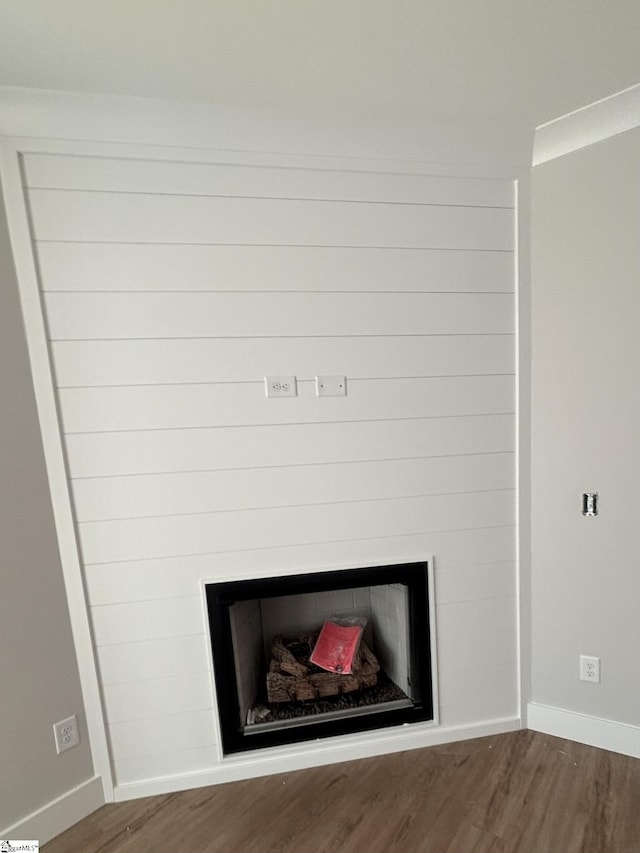 room details featuring crown molding, a fireplace, and hardwood / wood-style floors