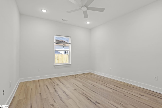 empty room with ceiling fan and light hardwood / wood-style flooring