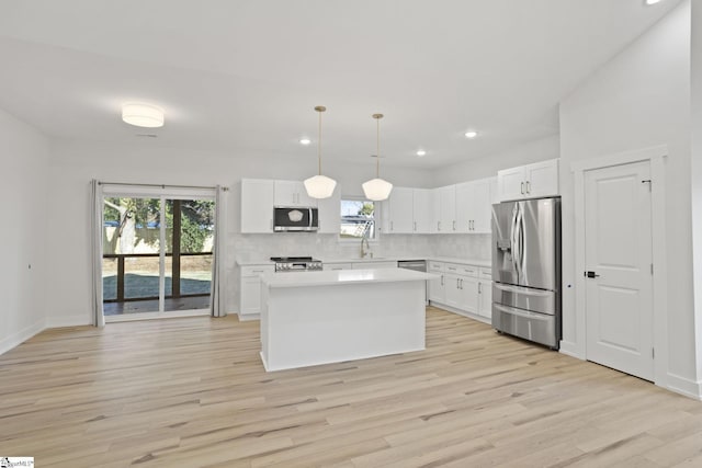 kitchen featuring white cabinets, pendant lighting, and appliances with stainless steel finishes