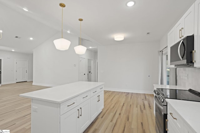 kitchen featuring stainless steel electric stove, pendant lighting, white cabinets, and light hardwood / wood-style floors