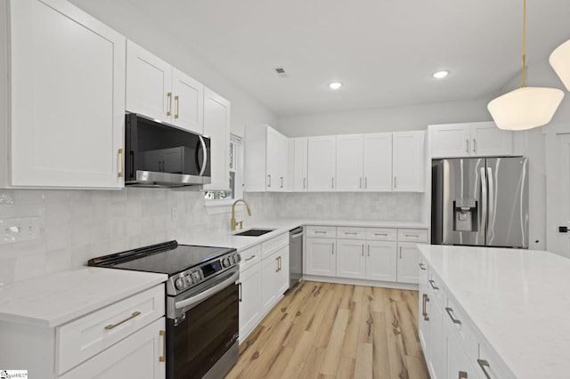 kitchen featuring white cabinets, decorative backsplash, stainless steel appliances, and sink