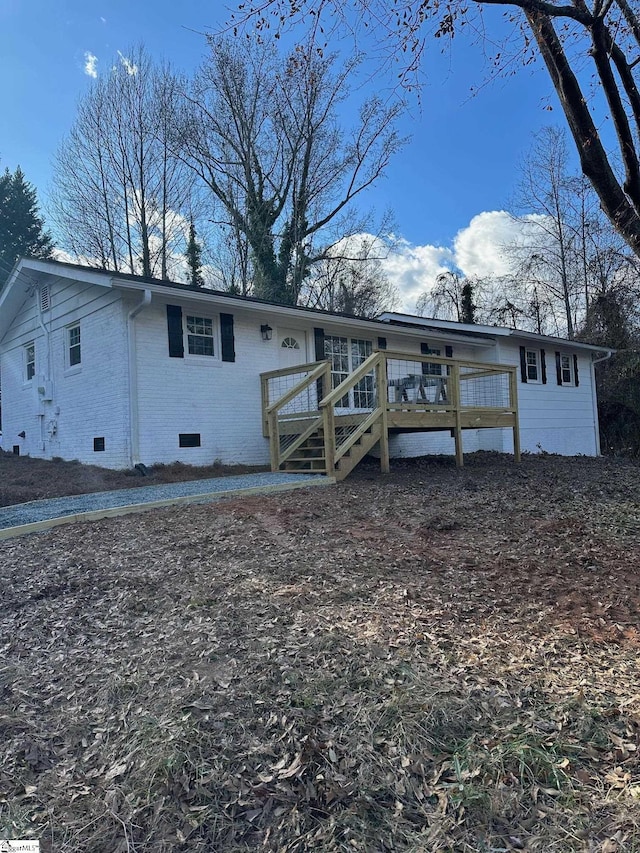 rear view of house featuring a wooden deck