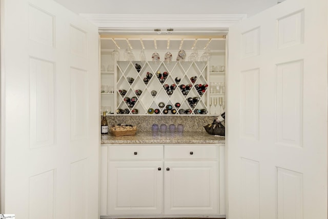 interior space with white cabinets, light stone countertops, and tasteful backsplash