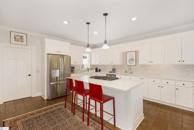 kitchen featuring white cabinets, sink, appliances with stainless steel finishes, tasteful backsplash, and a kitchen island