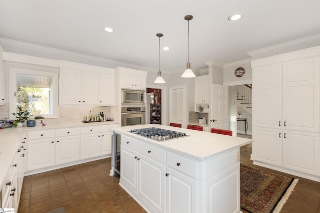 kitchen featuring stainless steel appliances, a kitchen island, backsplash, pendant lighting, and white cabinets