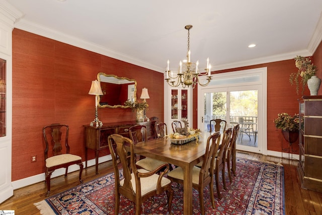 dining space featuring dark hardwood / wood-style floors, ornamental molding, and an inviting chandelier