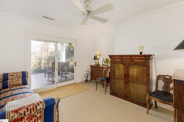 living area featuring carpet floors, ceiling fan, and ornamental molding