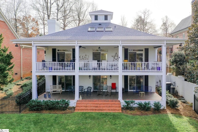 rear view of property featuring central AC, ceiling fan, a yard, and covered porch