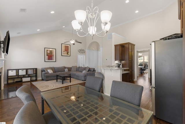 dining space featuring ceiling fan with notable chandelier, dark wood-type flooring, lofted ceiling, and ornamental molding