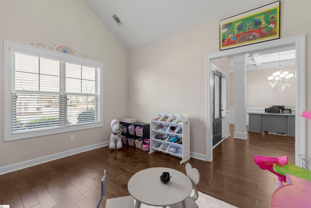 game room with a notable chandelier, dark wood-type flooring, and vaulted ceiling