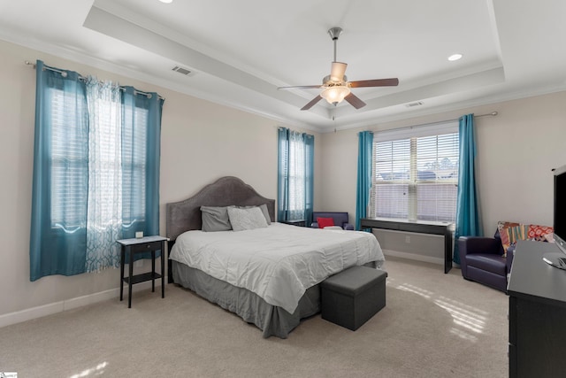 bedroom featuring a raised ceiling, ceiling fan, light carpet, and ornamental molding