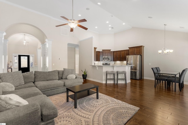 living room with high vaulted ceiling, dark wood-type flooring, ceiling fan with notable chandelier, and ornamental molding