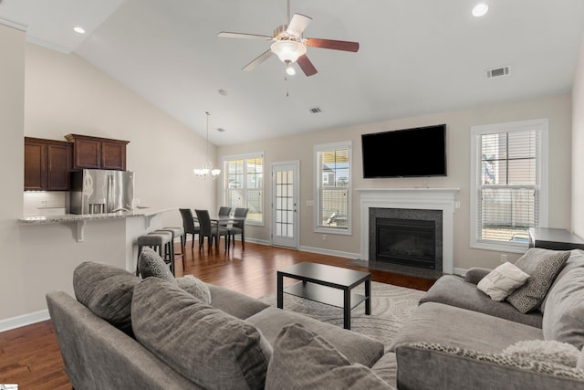 living room featuring ceiling fan with notable chandelier, high vaulted ceiling, and dark wood-type flooring