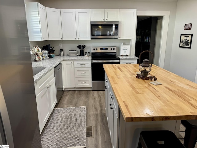 kitchen featuring wood counters, white cabinets, and appliances with stainless steel finishes