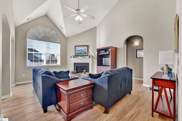 living room featuring ceiling fan, light hardwood / wood-style flooring, and high vaulted ceiling